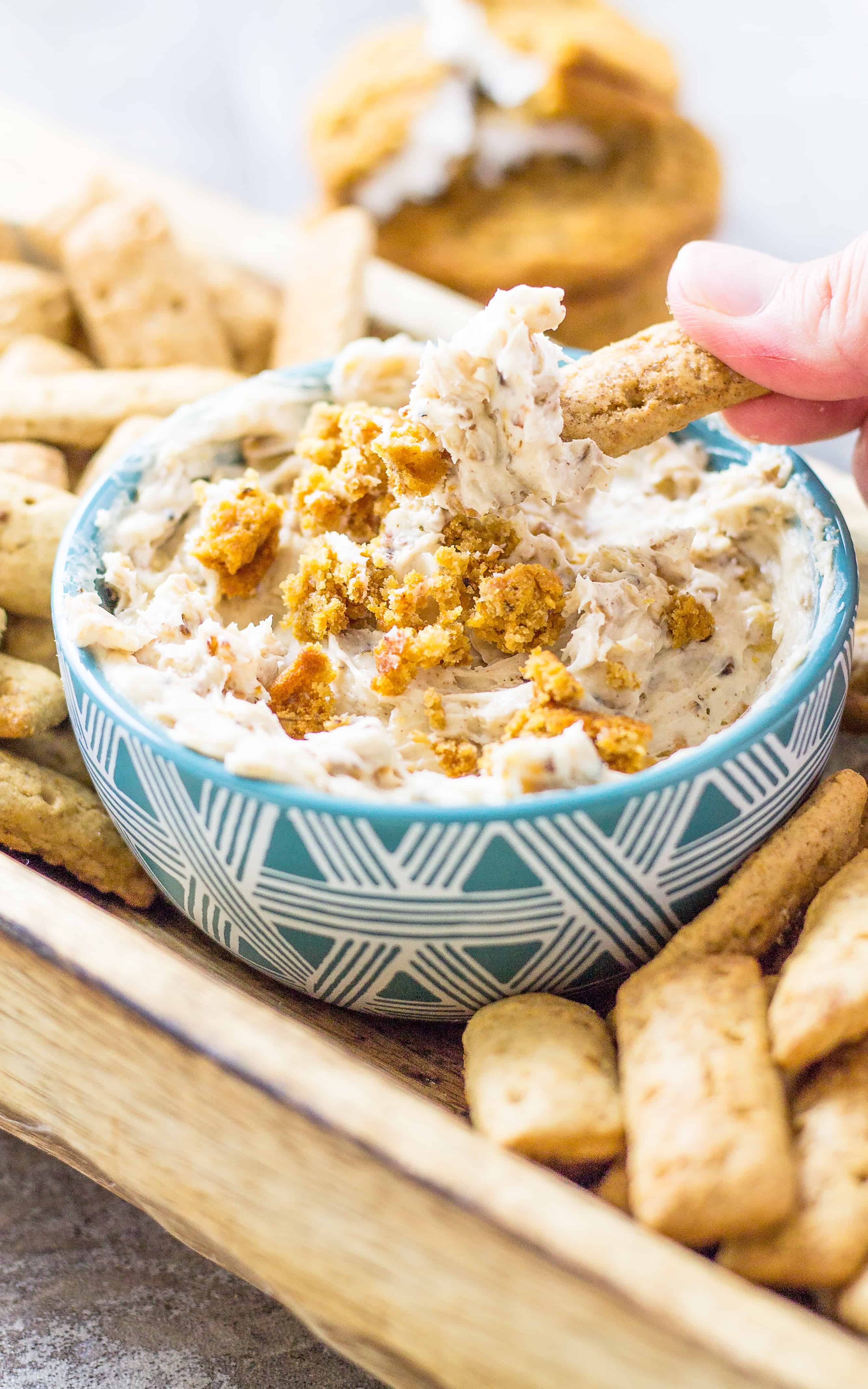 Hand dipping a cracker in to the Oatmeal cream pie dip