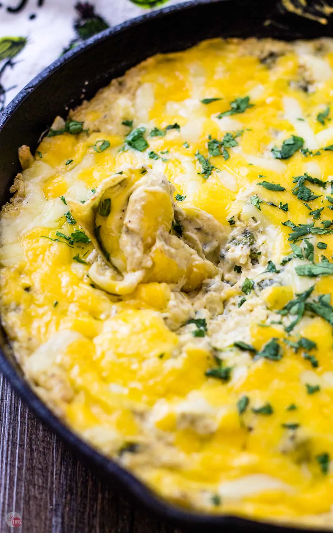 close up of all this cheesy goodness mixed with poblano peppers and spicy Southwest Seasoning in a cast iron skillet