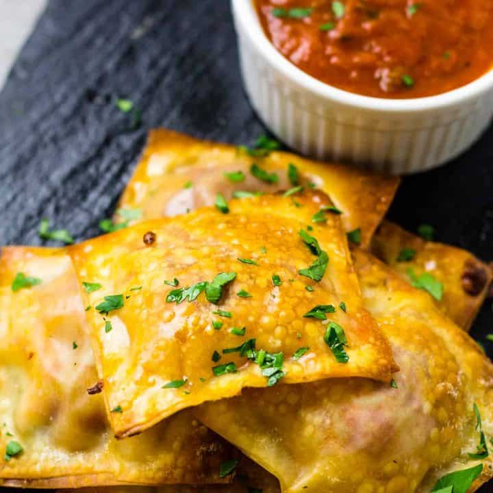 Pepperoni Pizza Packets with a side of marinara sauce on a black platter