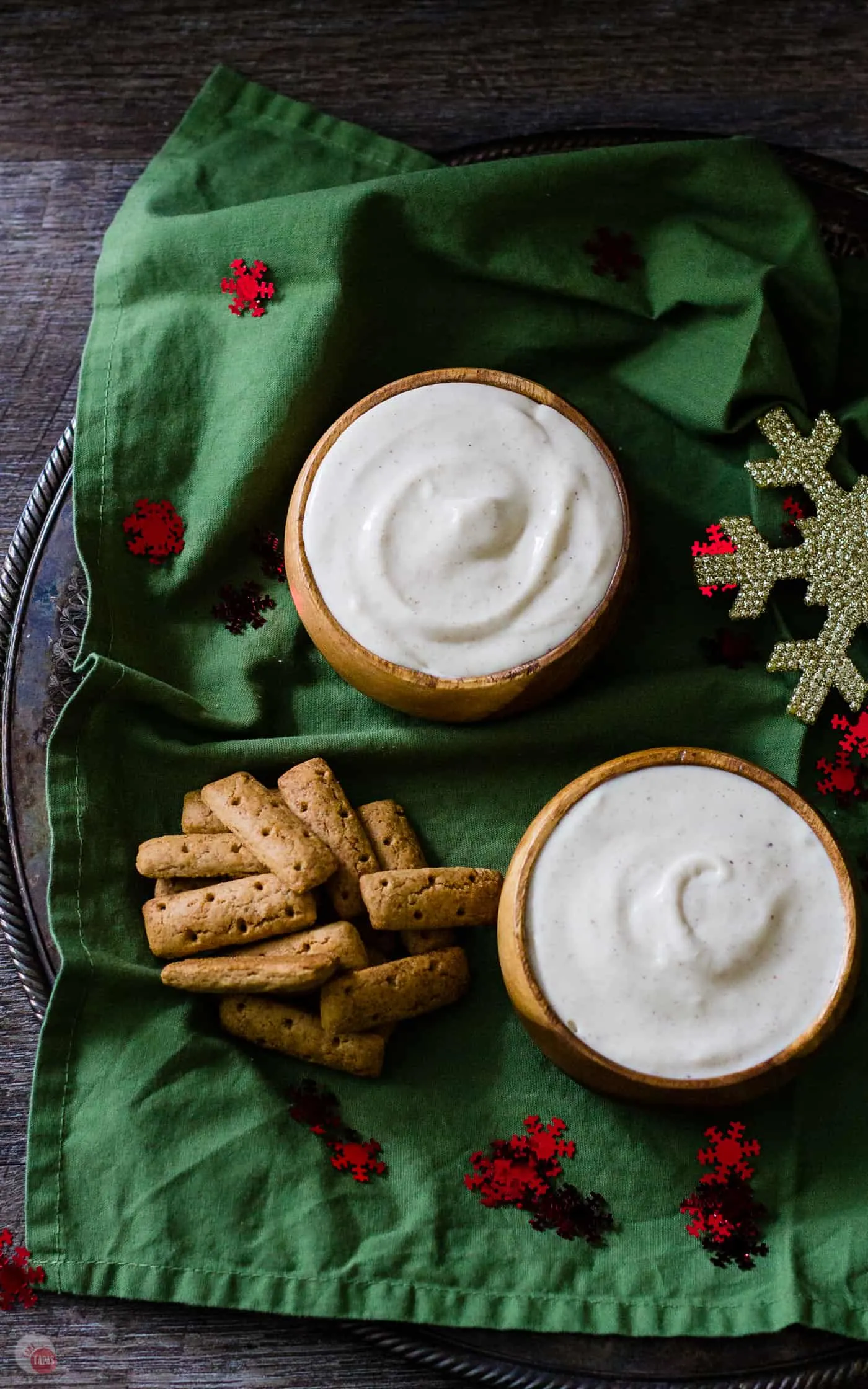 overhead picture of two bowls of eggnog dip on green napkin