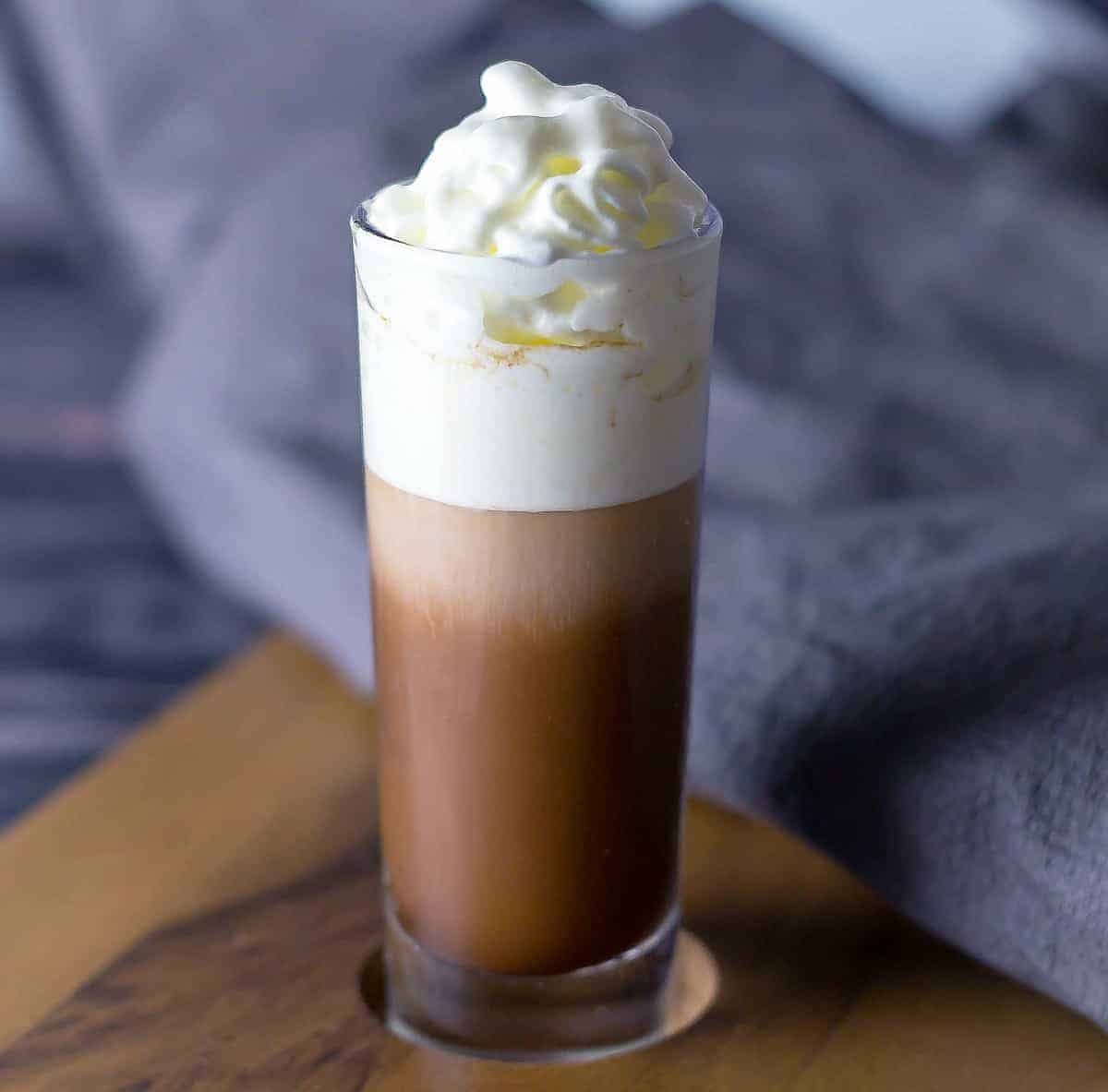 Close up look at Salted Caramel Kahlua Layer Shot on a serving board with a grey napkin behind it