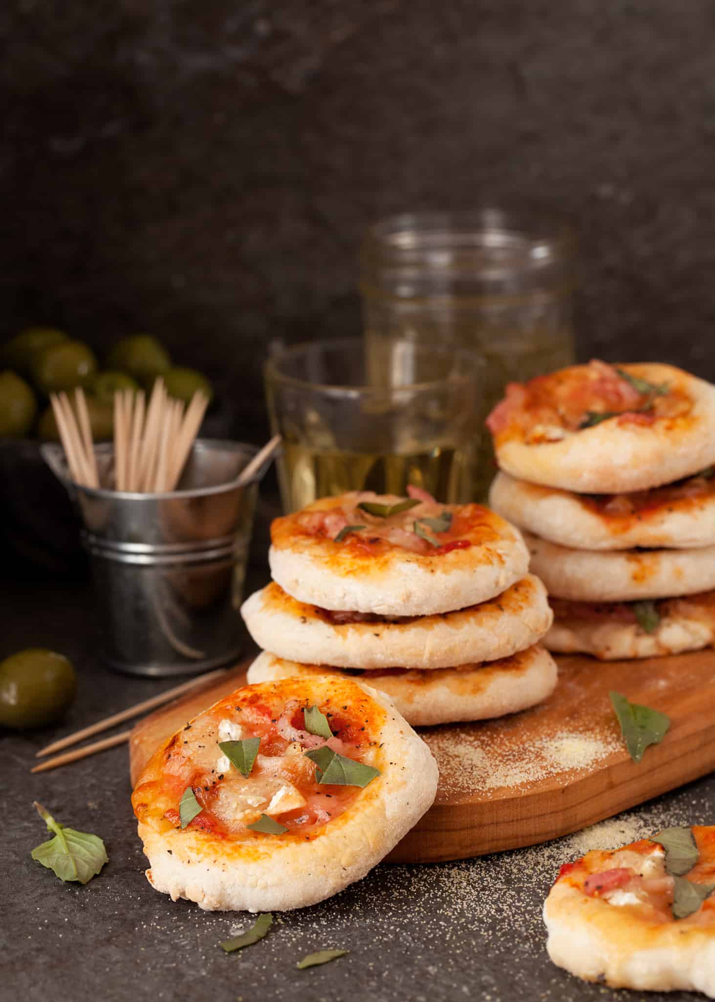 Bacon Brie Basil Mini Pizzas stacked on a wood plate