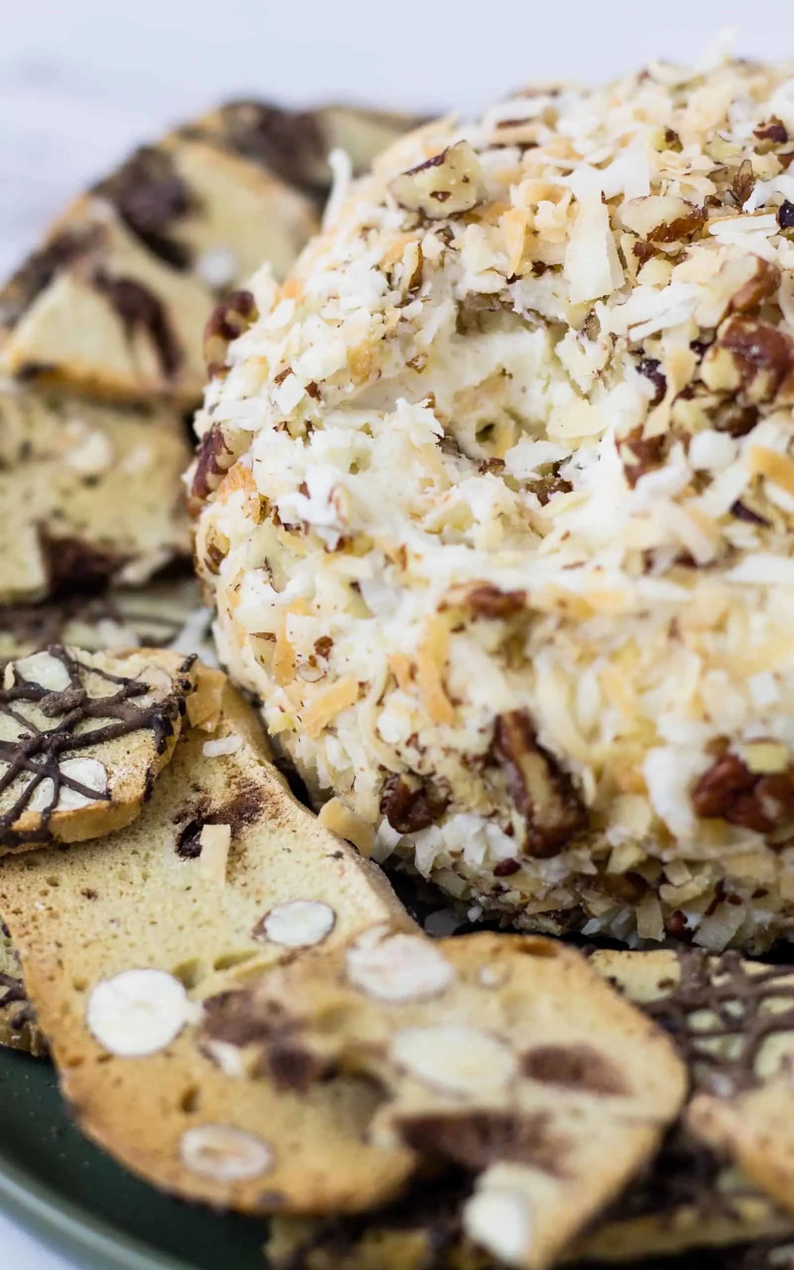 close up of Italian Cream Cake Cheese Ball and thin biscotti cookie pieces on a plate