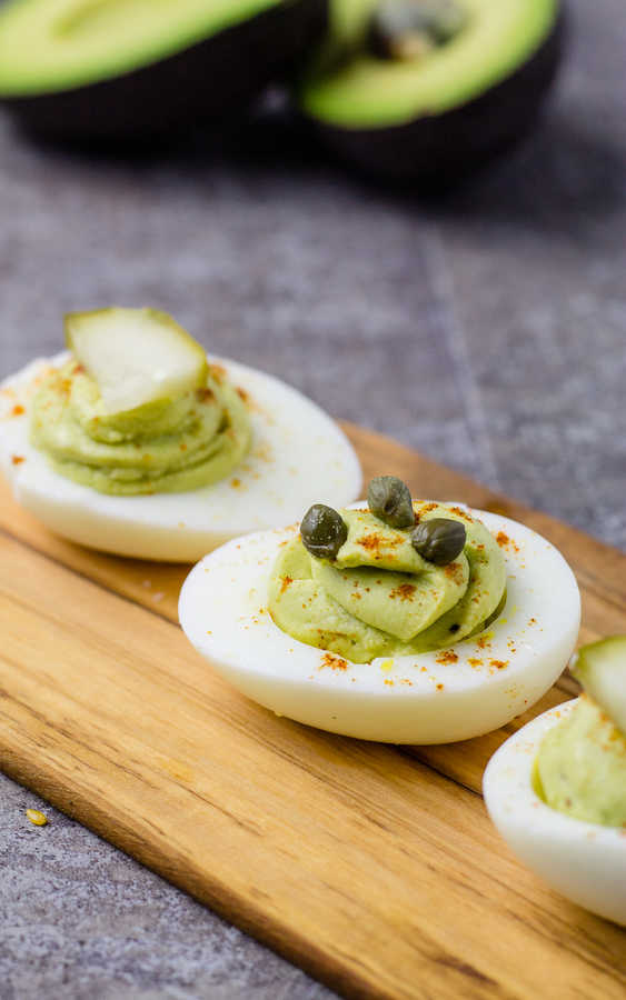 deviled eggs on wood plate with capers