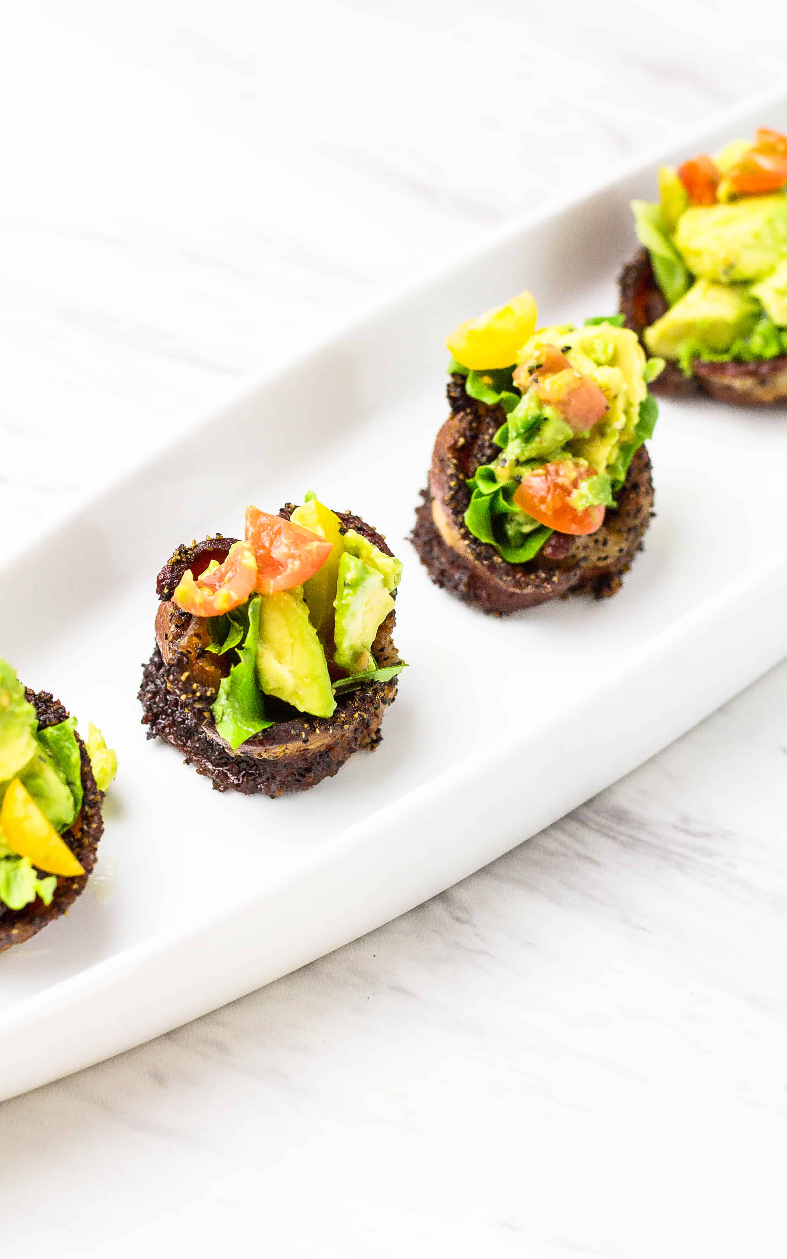 BLT Bacon Cups with Avocado in a row on a white platter