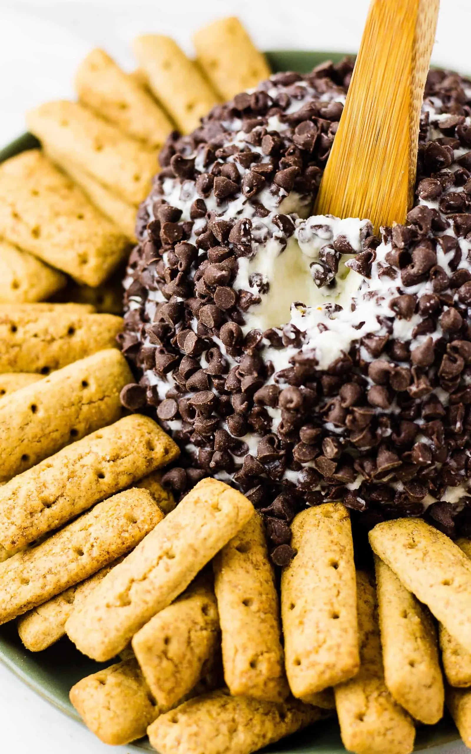 close up of Cannoli Cheese Ball with graham cracker cookie sticks on a plate