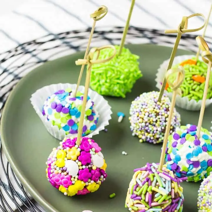 Several skewered no bake cheesecake bites on a plate