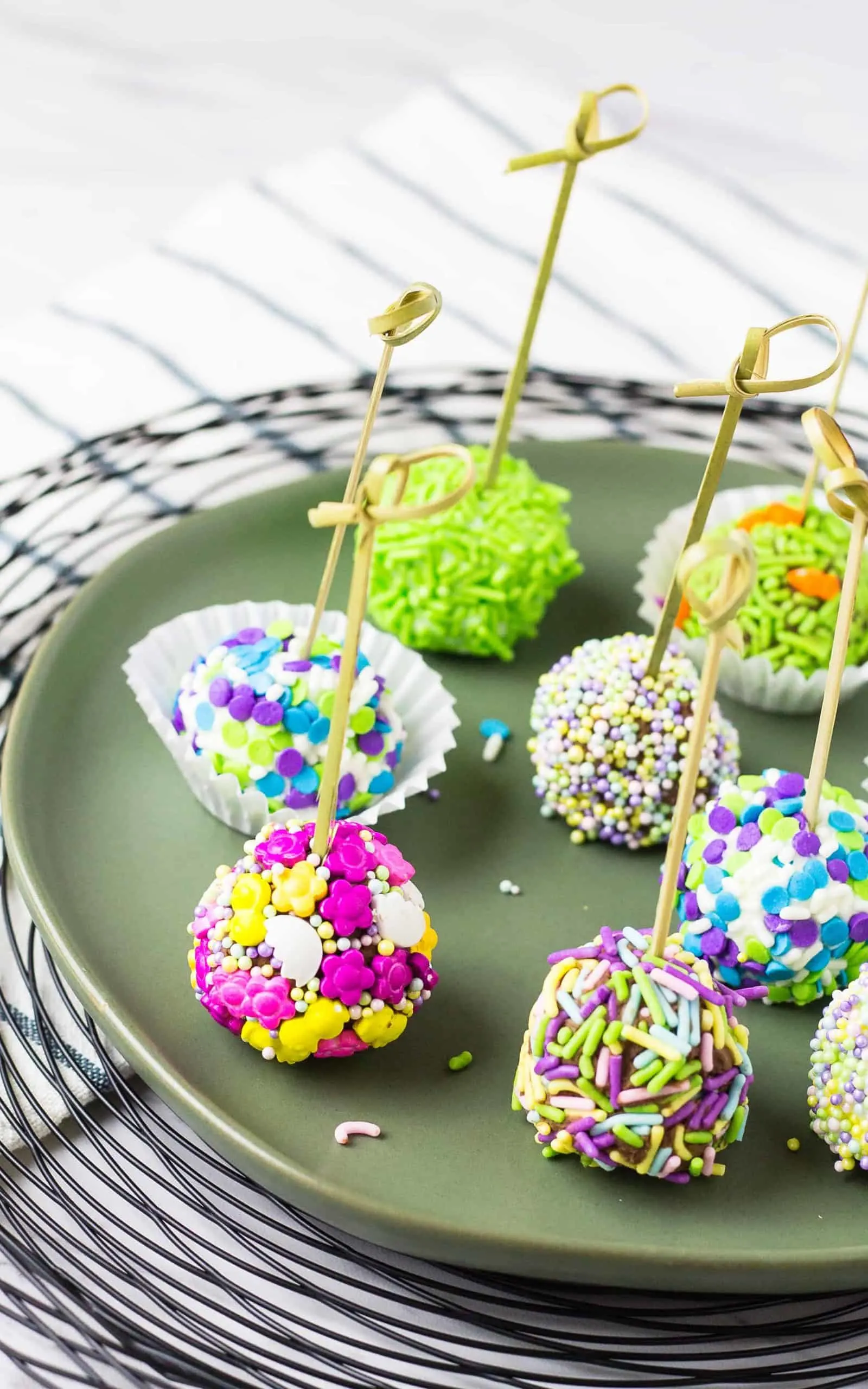 Several skewered no bake cheesecake bites on a plate