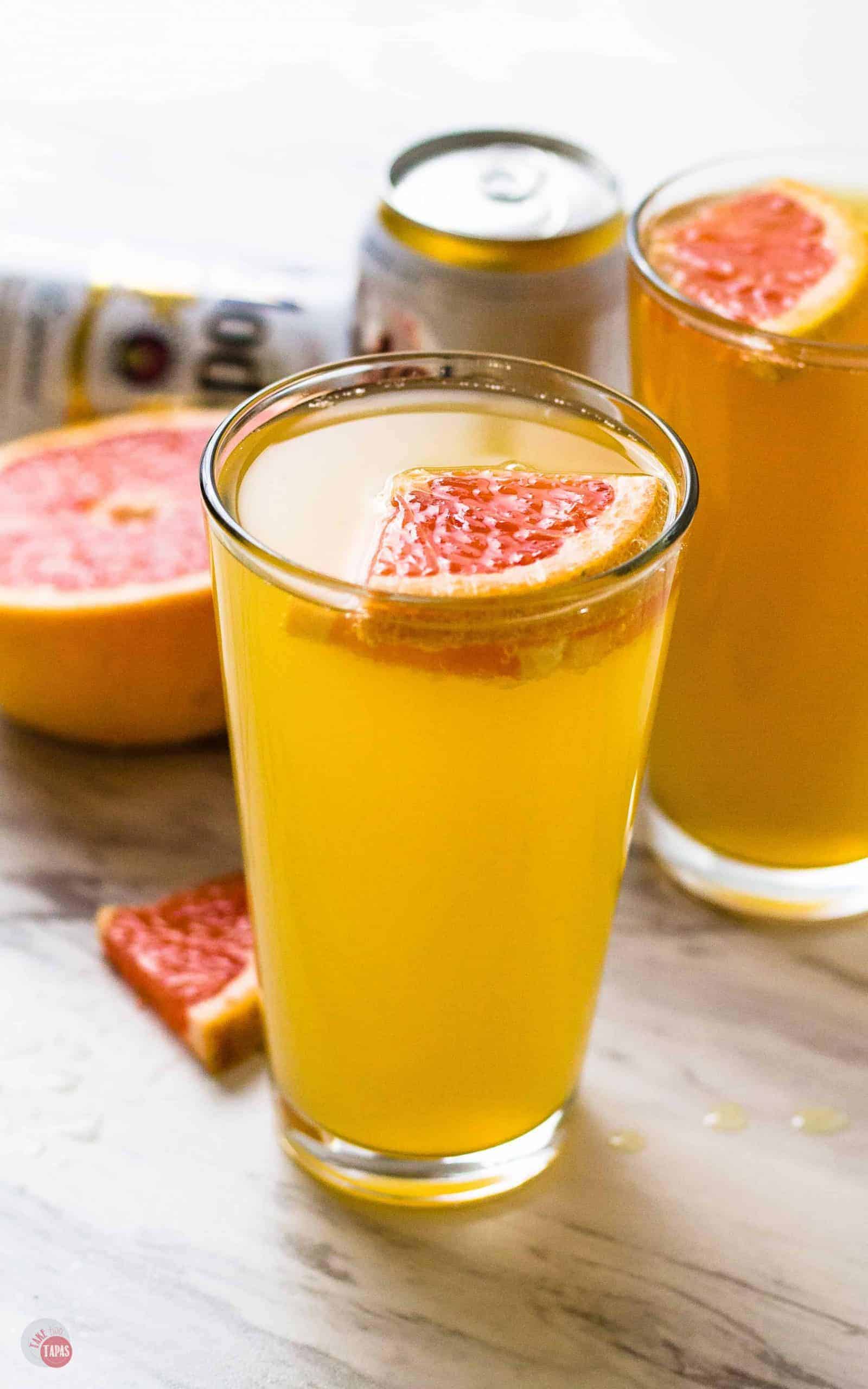 side view of Grapefruit Shandy on a white and black surface