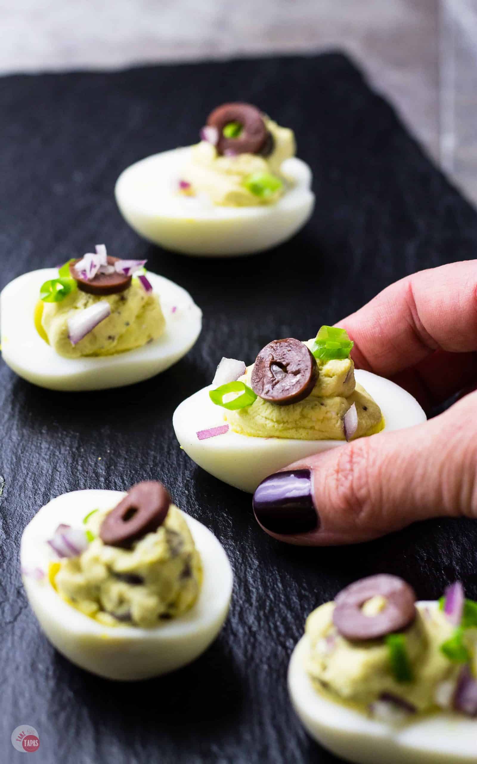 Mediterranean Deviled Eggs on a black platter