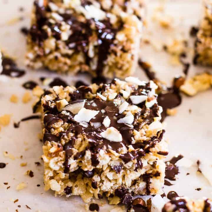 Recently drizzled Almond Joy Rice Krispie squares on parchment paper