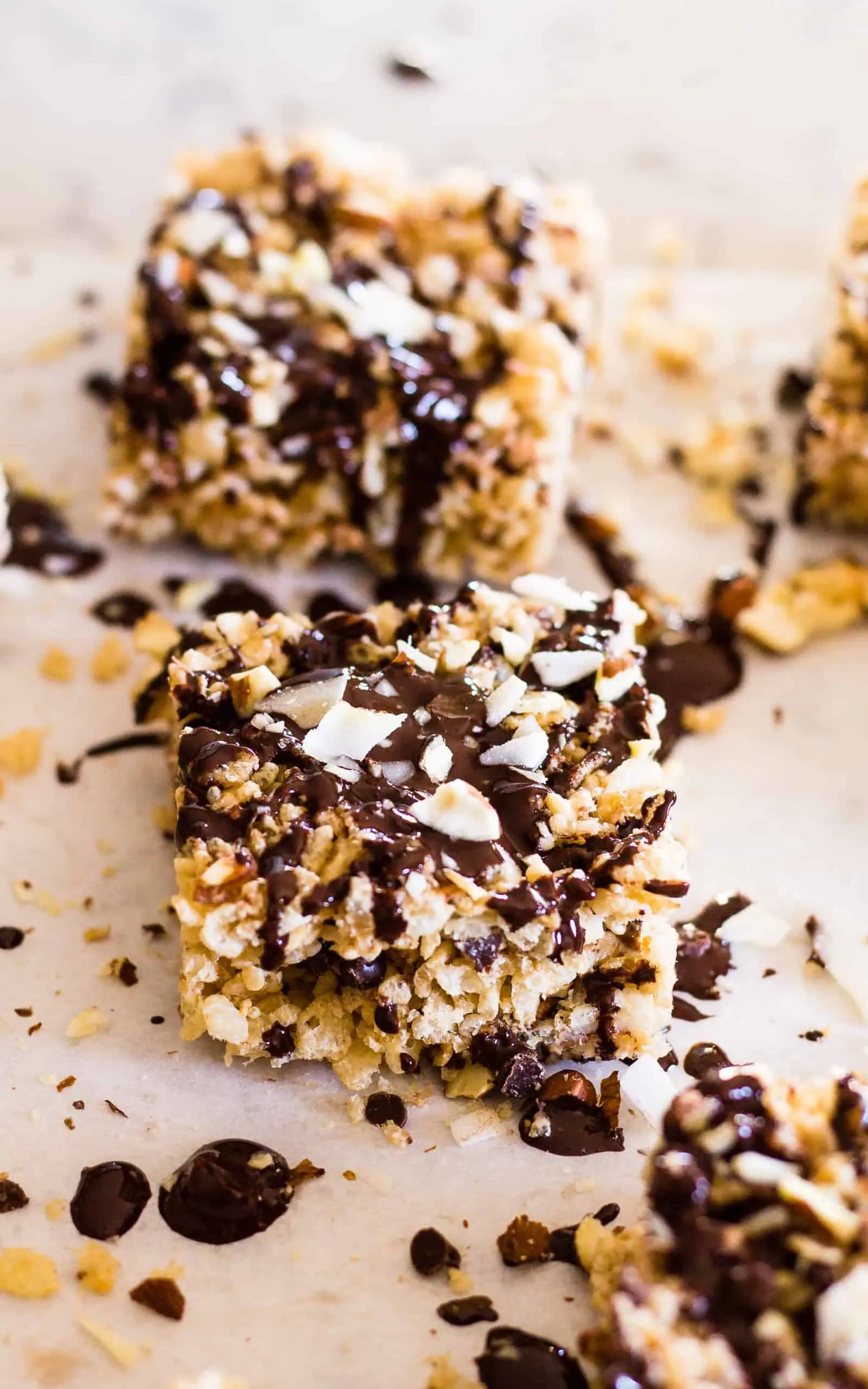 Recently drizzled Almond Joy Rice Krispie squares on parchment paper