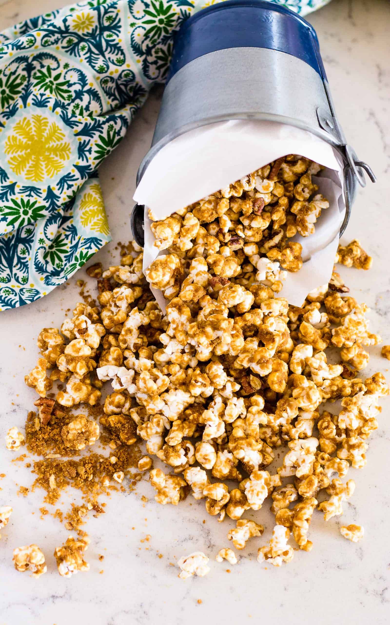 overhead of Grandma's Caramel Corn spilling out on to table from container