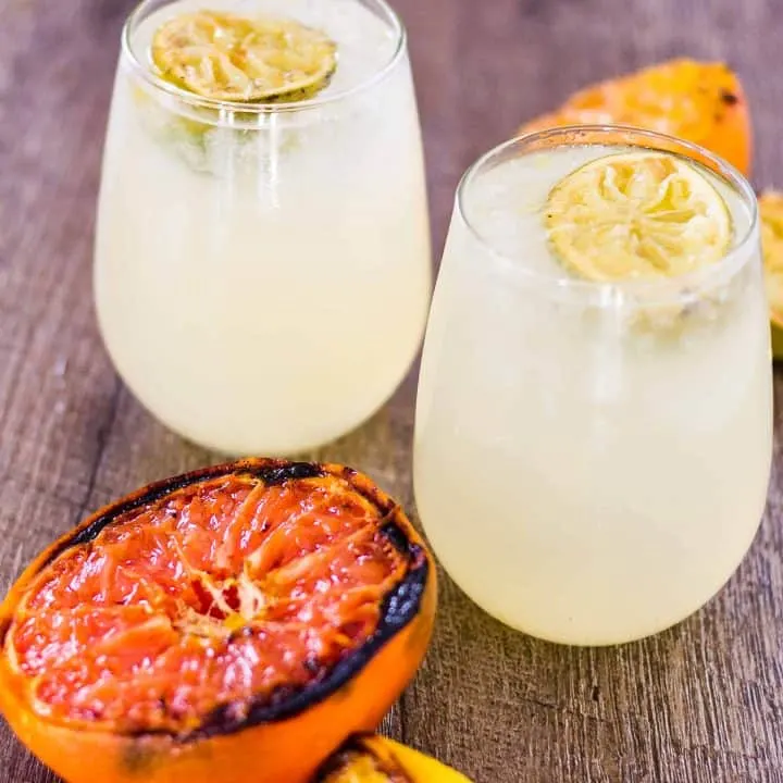 Caramelized Citrus Smash cocktails and grilled citrus on a table