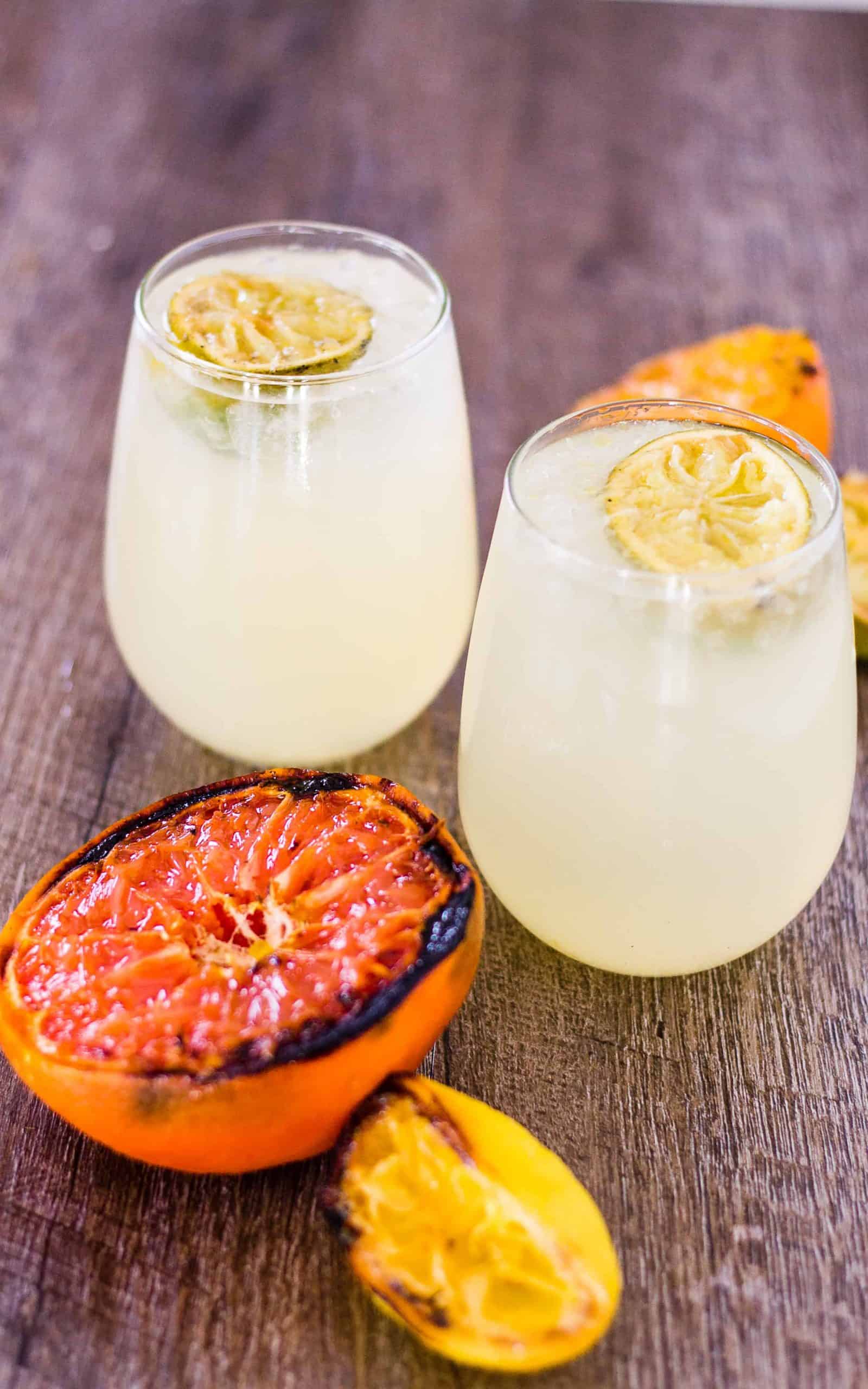 Caramelized Citrus Smash cocktails and grilled citrus on a table