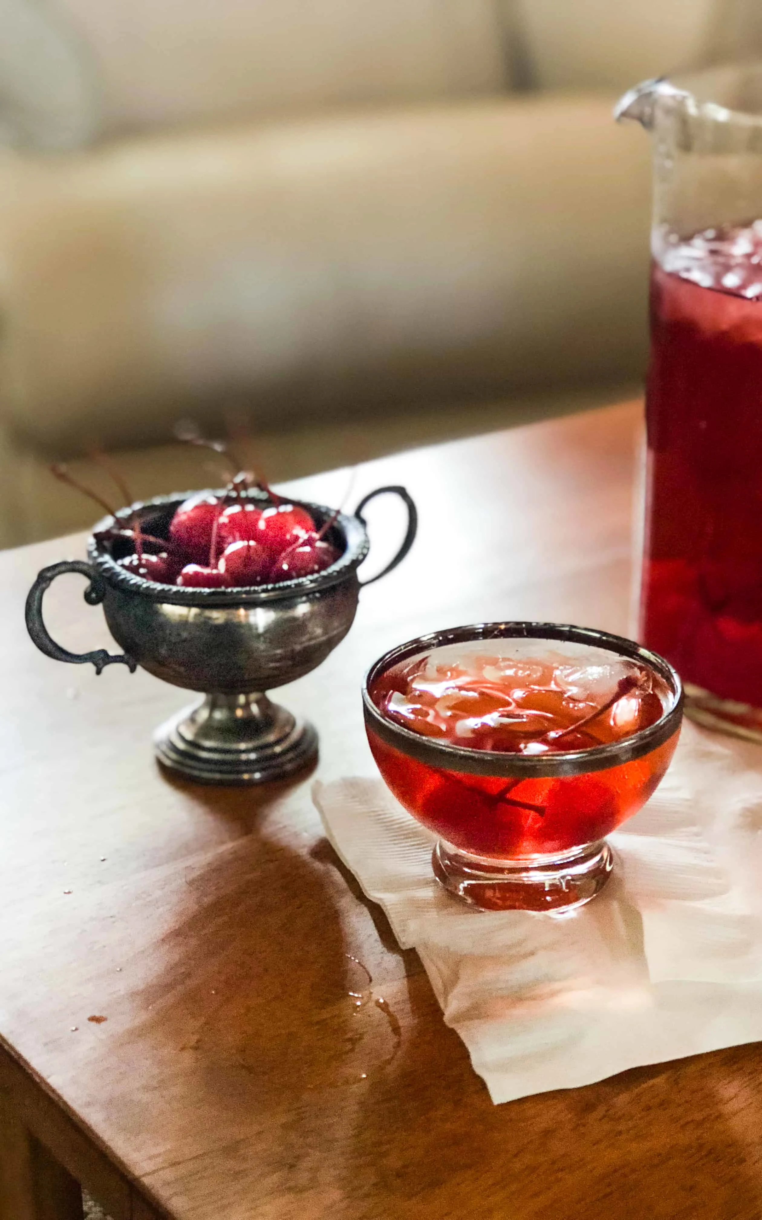 Maraschino Cherries in a container and a glass of the manhattan punch