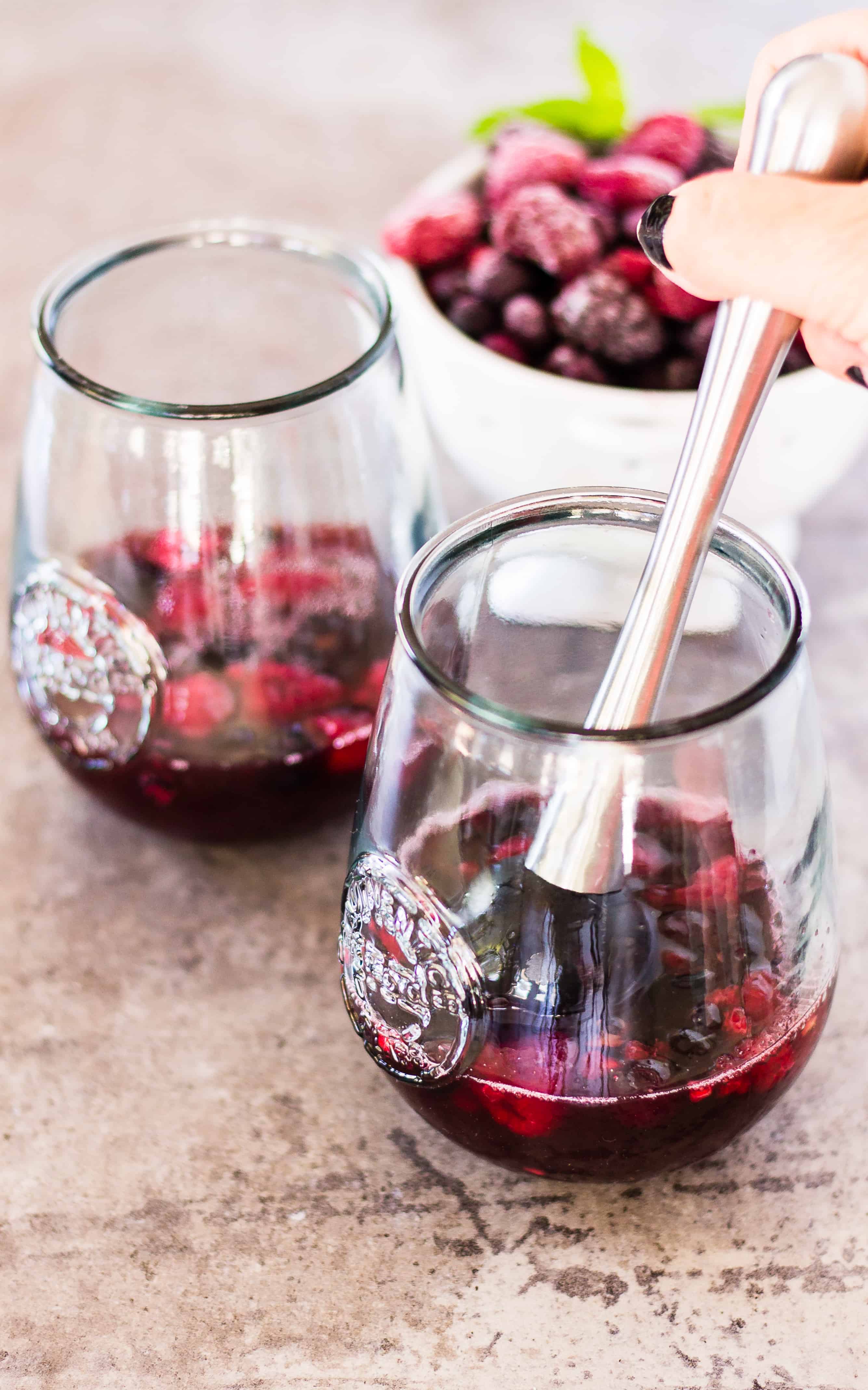 Muddle the berries with orange juice and lemon juice in the Skinny Sangria Spritzer | Take Two Tapas | #Sangria #Spritzer #SkinnyCocktails #WineCocktails #EasyCocktails #SimpleCocktails