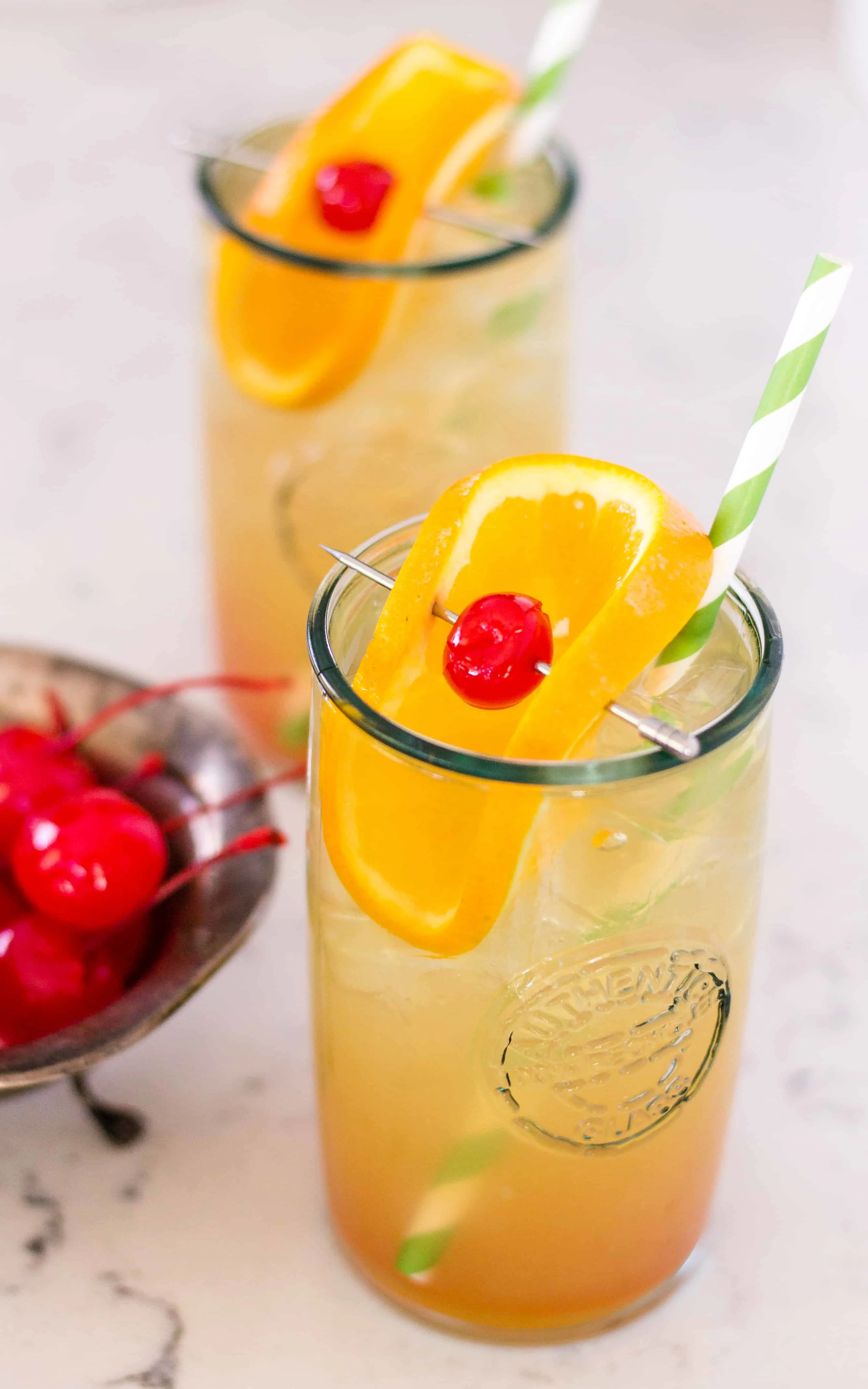 amaretto sour cocktail with an orange and cherry garnish