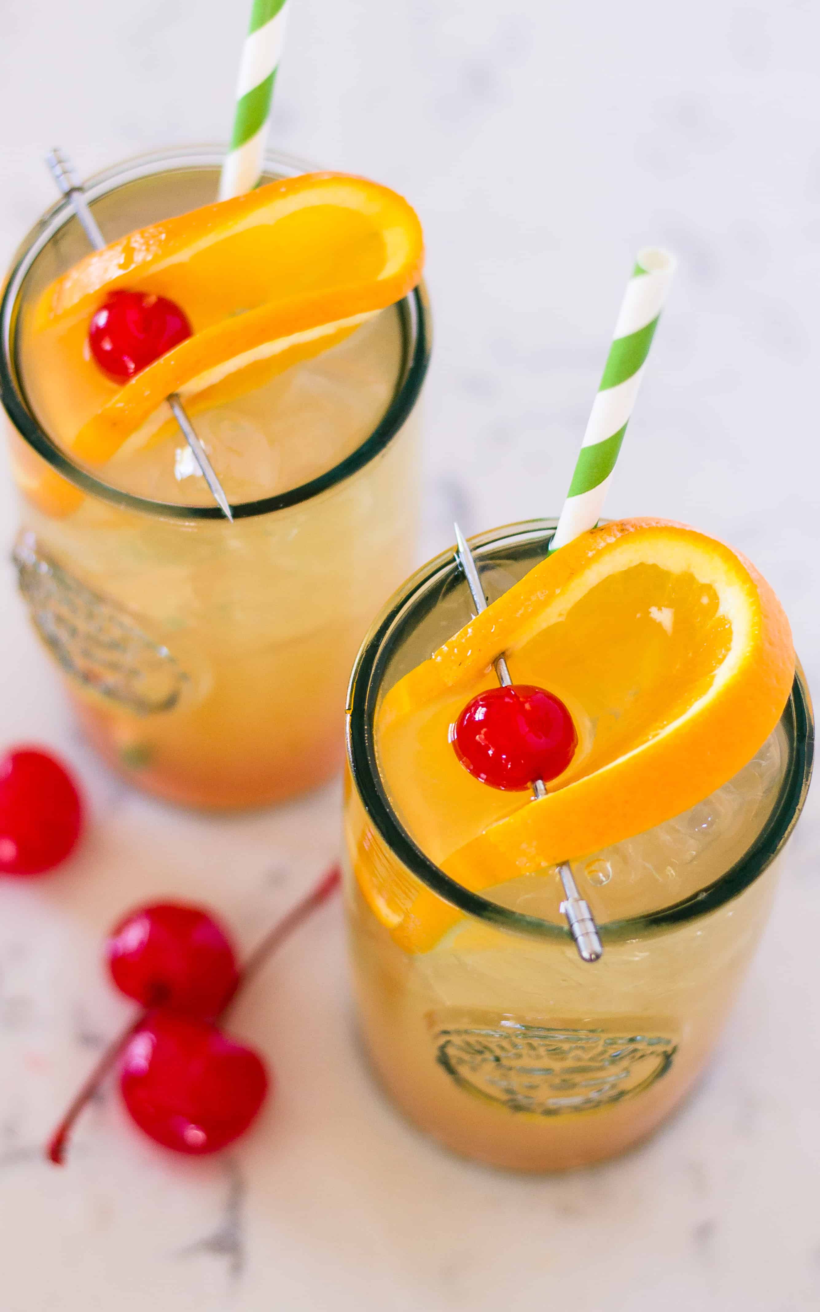 two cocktails with orange garnish