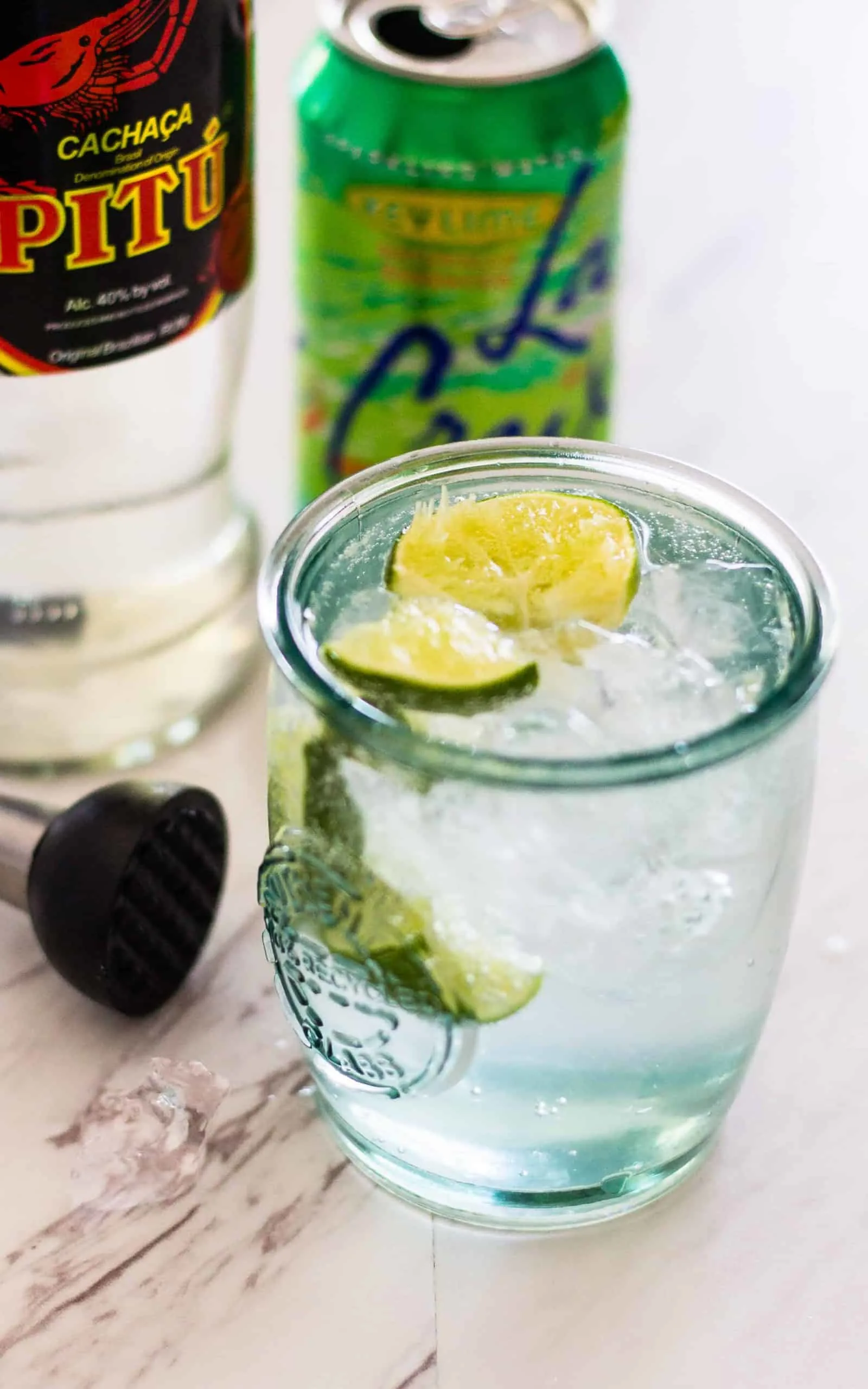 Jalapeño Caipirinha Cocktail with bottle and can of La Croix in background