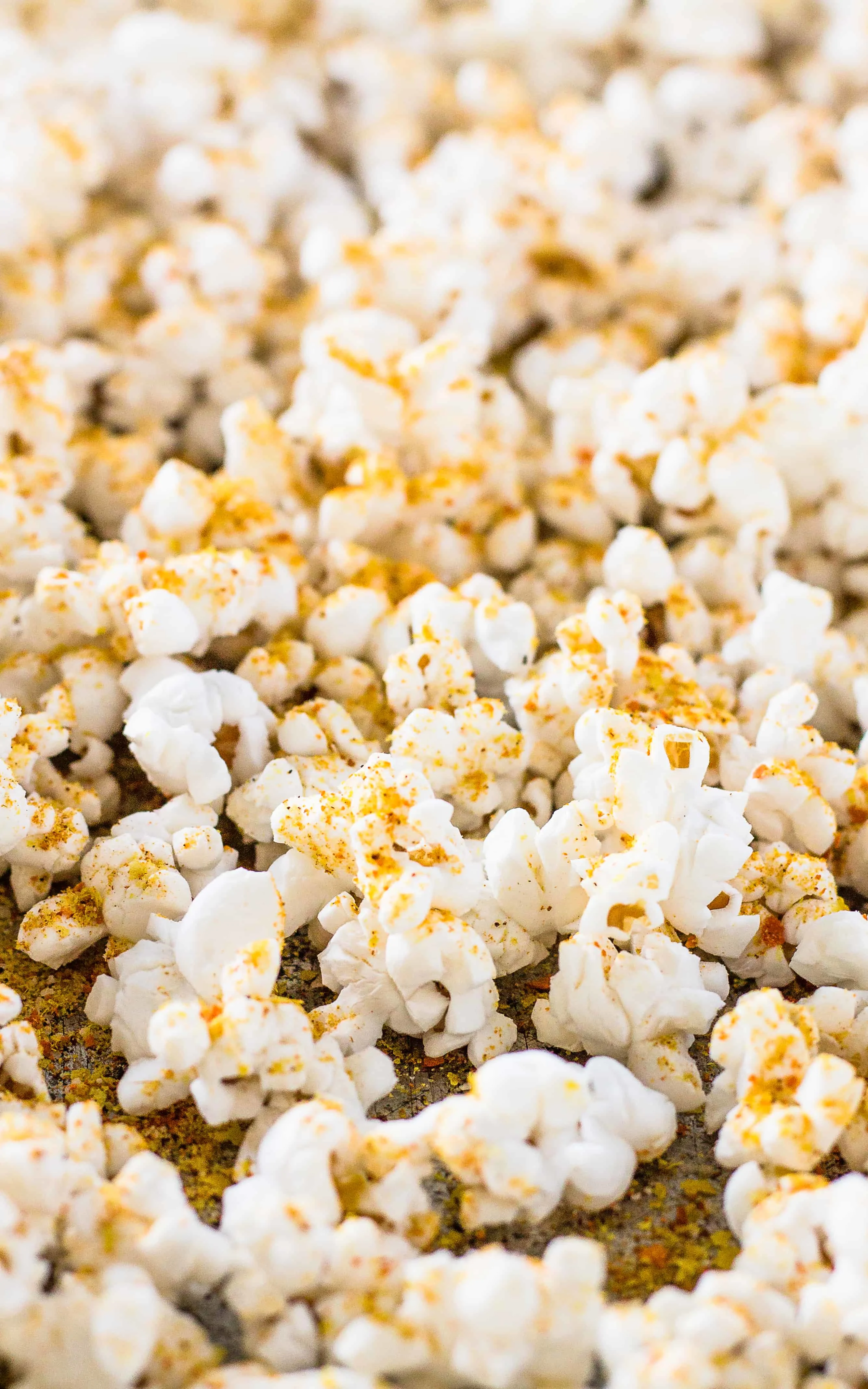 Spread the popcorn on the pan before sprinkling the Spicy Nacho Popcorn