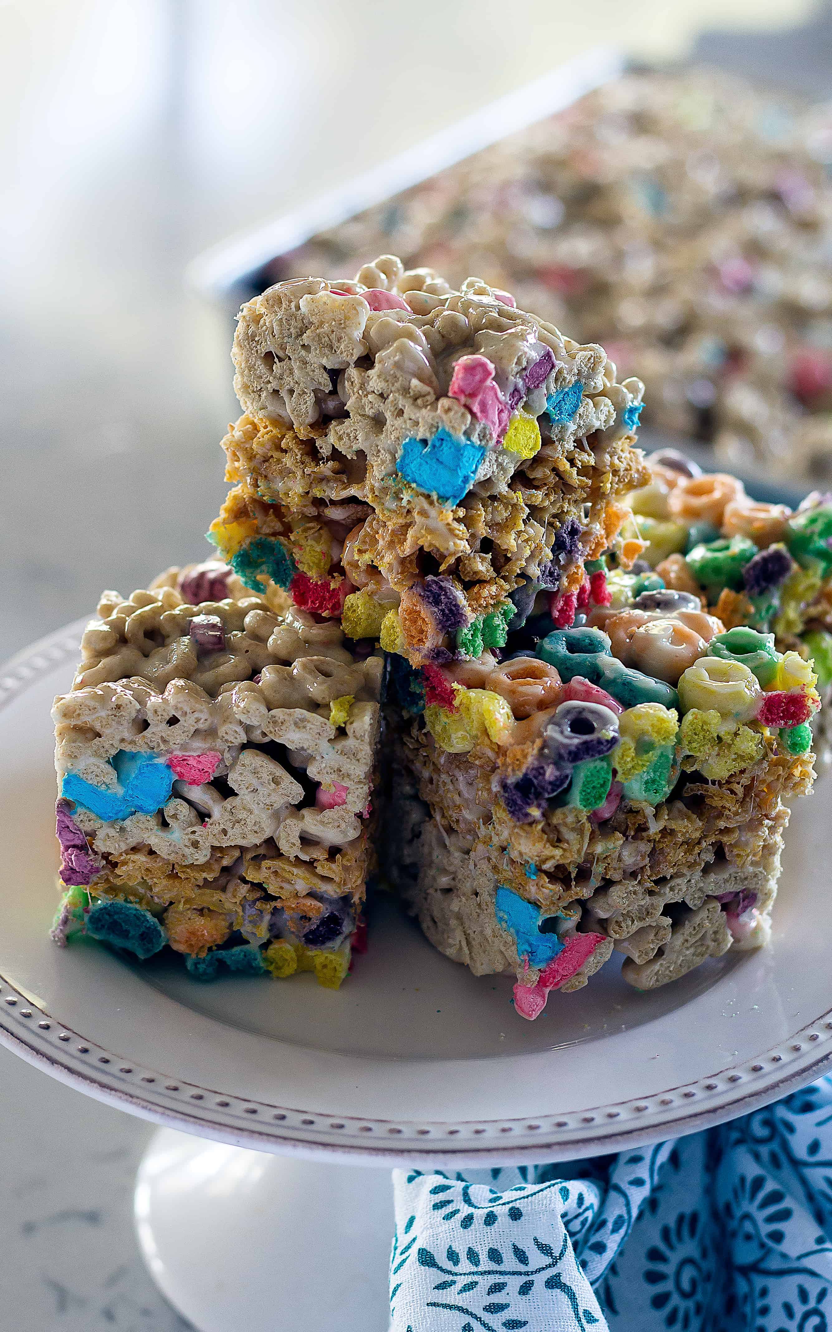 A smaller deeper pan works best to showcase the layers of cereal! Layered Cereal Treat Bars | Take Two Tapas | #CerealBars #RiceKrispiesTreats #FruitLoops #FrostedFlakes #LuckyCharms #CerealRecipes #KidsTreats #AfterSchoolSnacks