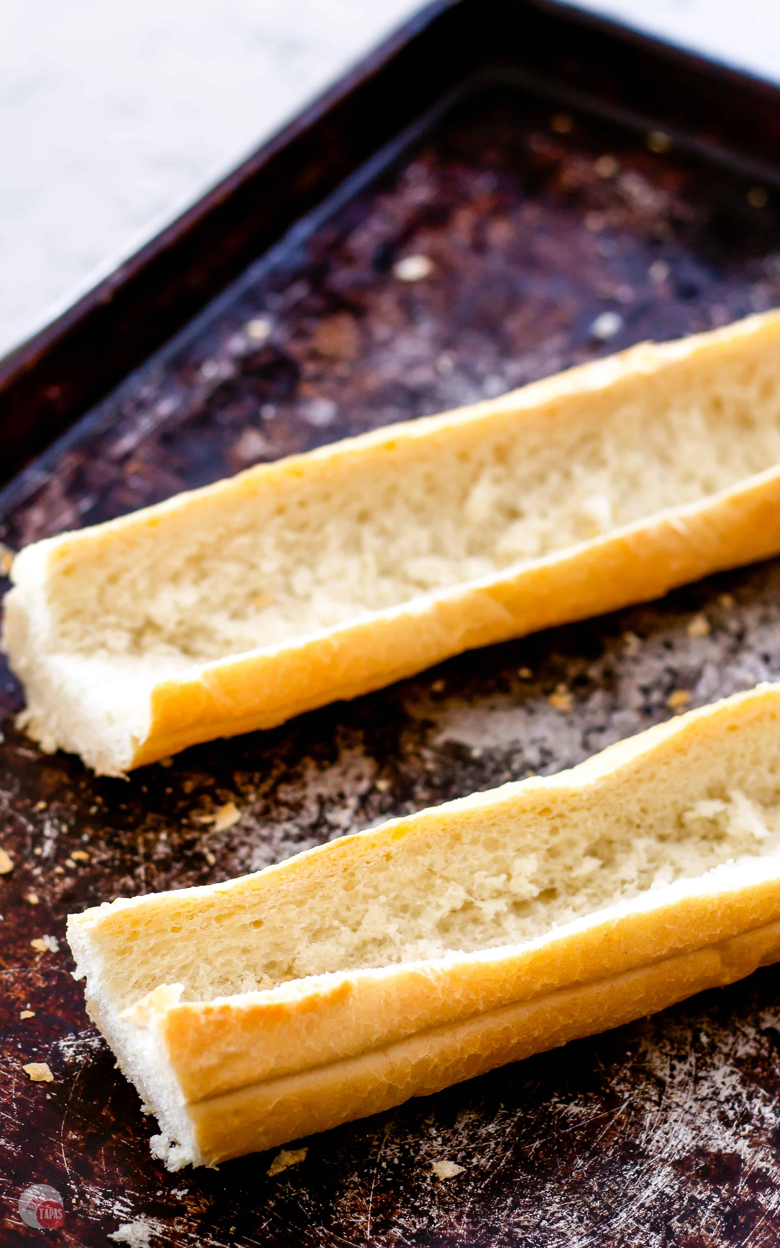 2 halves of bread on a sheet pan