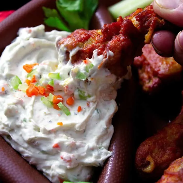 dipping a chicken wing in to the sauce