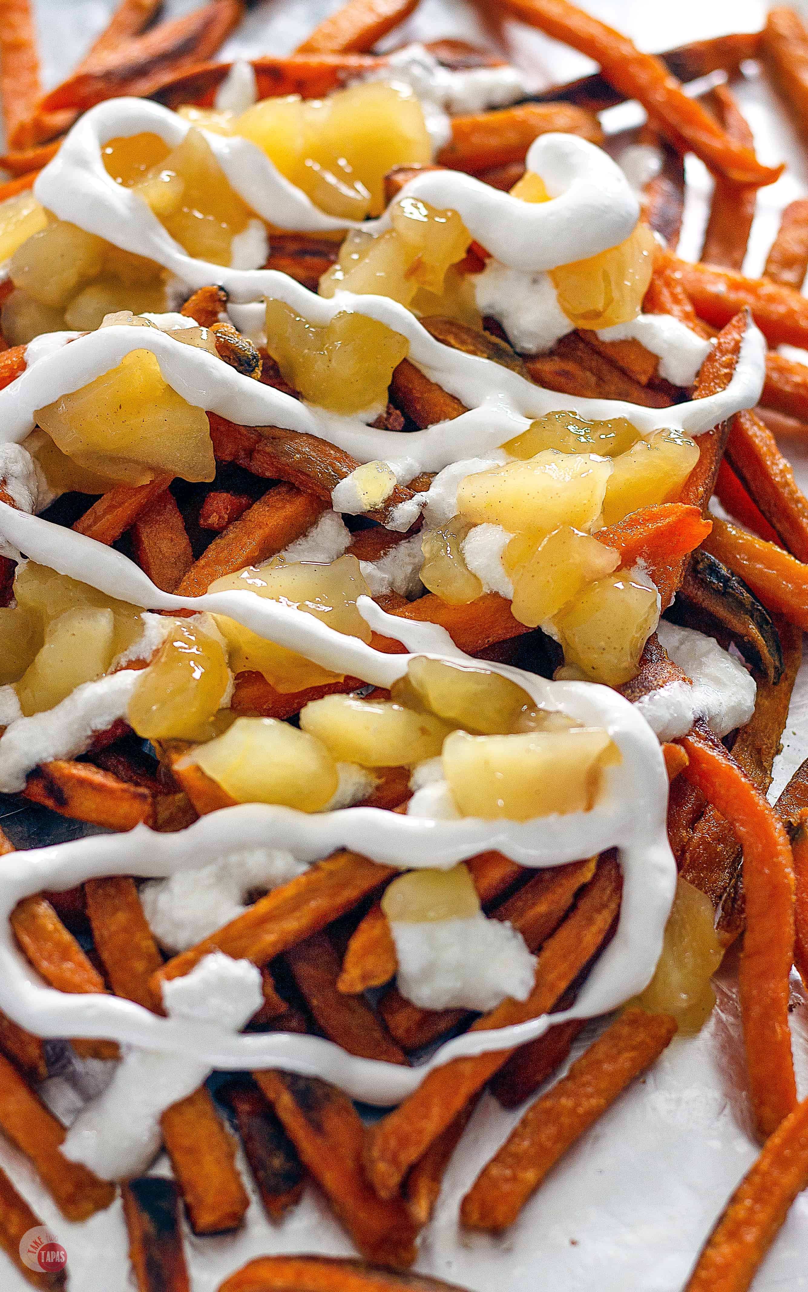 Crispy baked sweet potatoes covered with fluffy marshmallow, cinnamon apples, and crunchy pecans and caramel popcorn! | Take Two Tapas | #PoutineRecipes #SweetPotatoRecipes #FrenchFryRecipes
