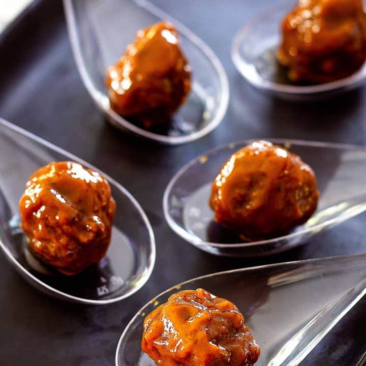party meatballs in clear spoons on a platter