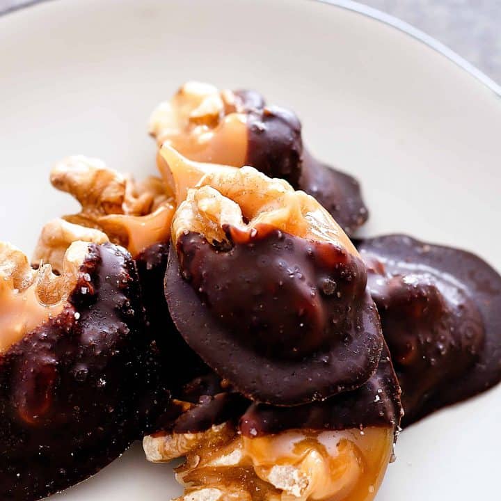 close up picture of Individual Salted Dark Chocolate Walnut Amaretto Turtles on a white plate