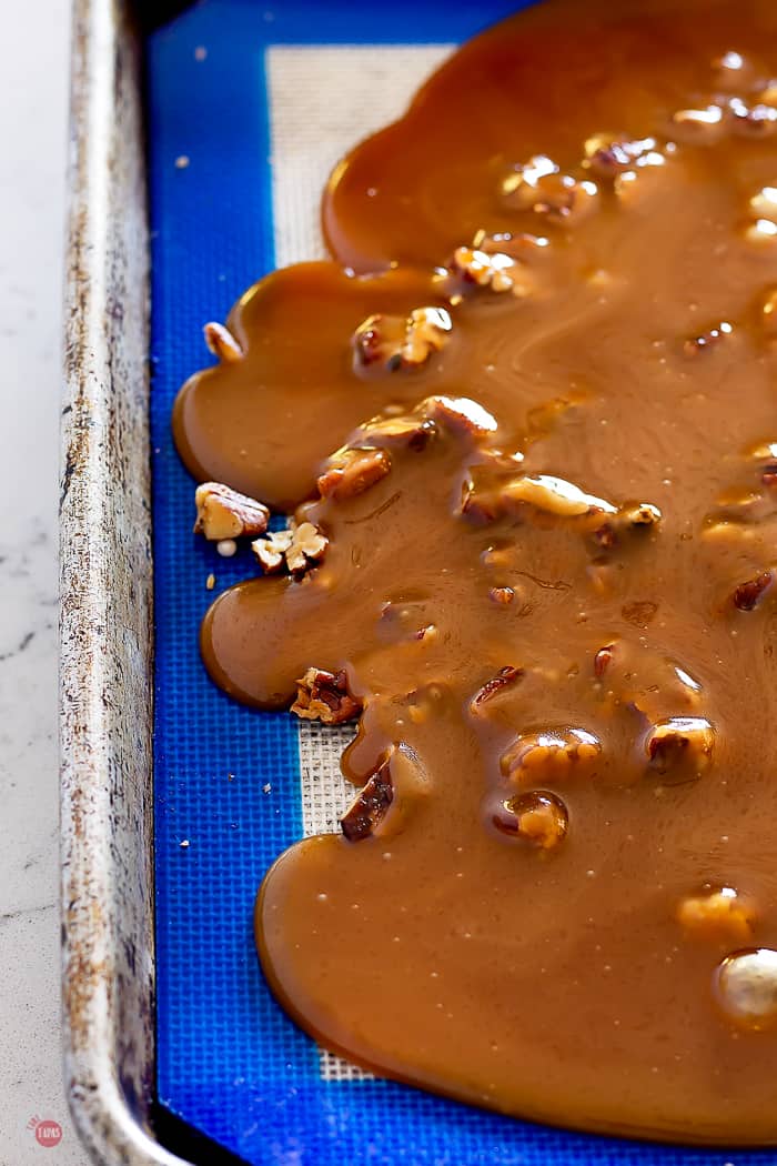the hot Pecan Butter Rum Toffee mix on a silicone baking sheet