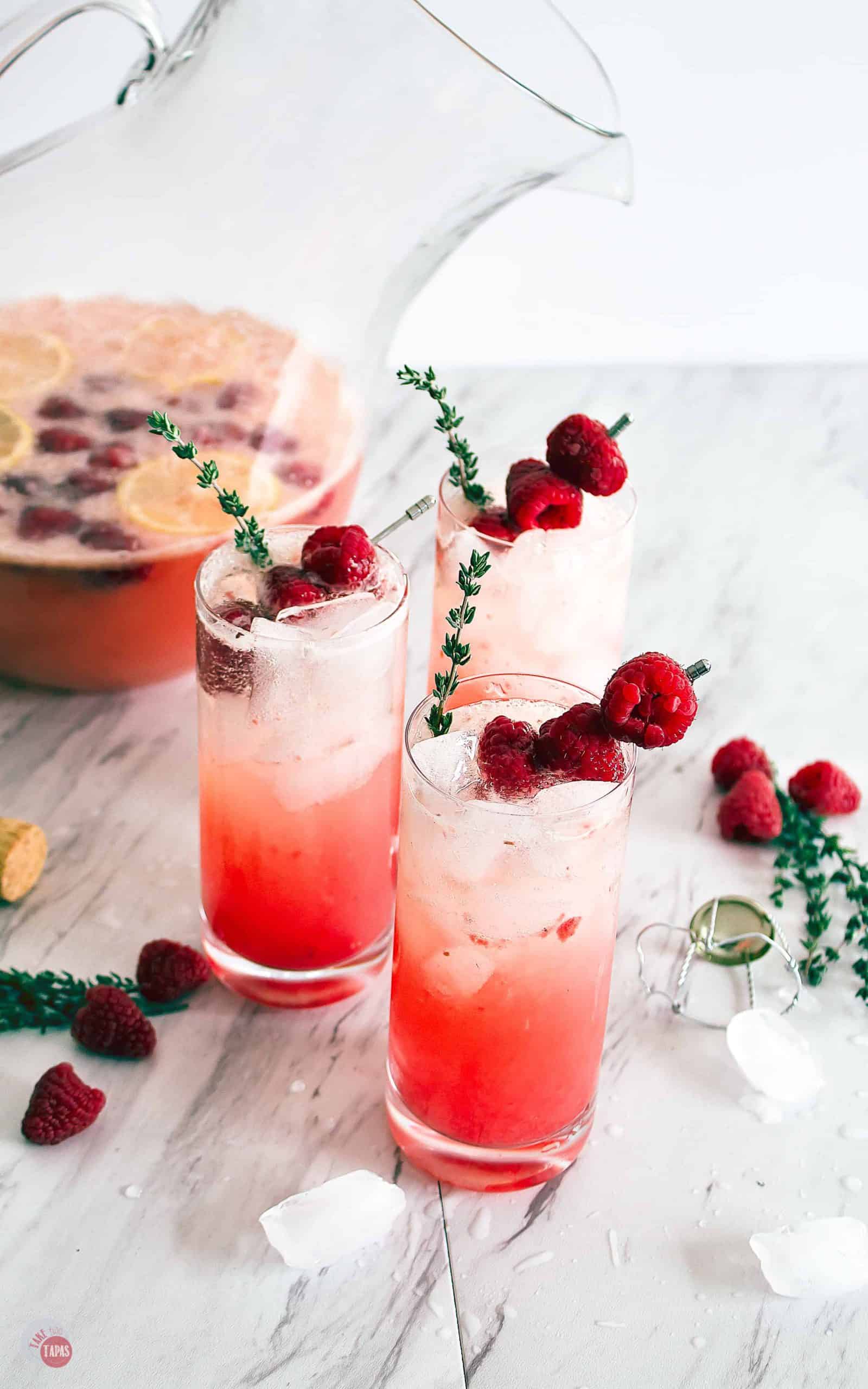 Three glasses of Raspberry Thyme Prosecco Punch on a table