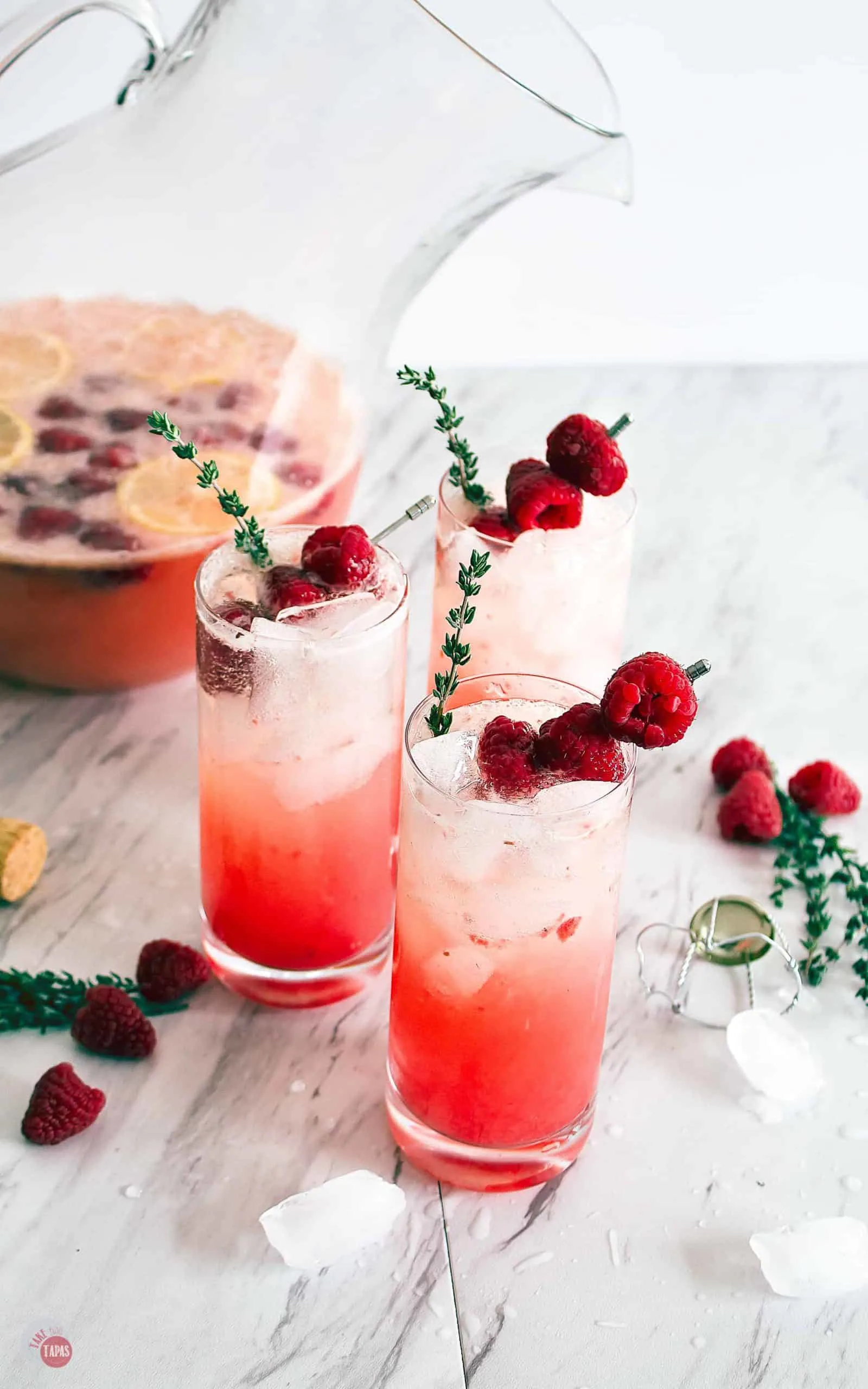 Three glasses of Raspberry Thyme Prosecco Punch on a table