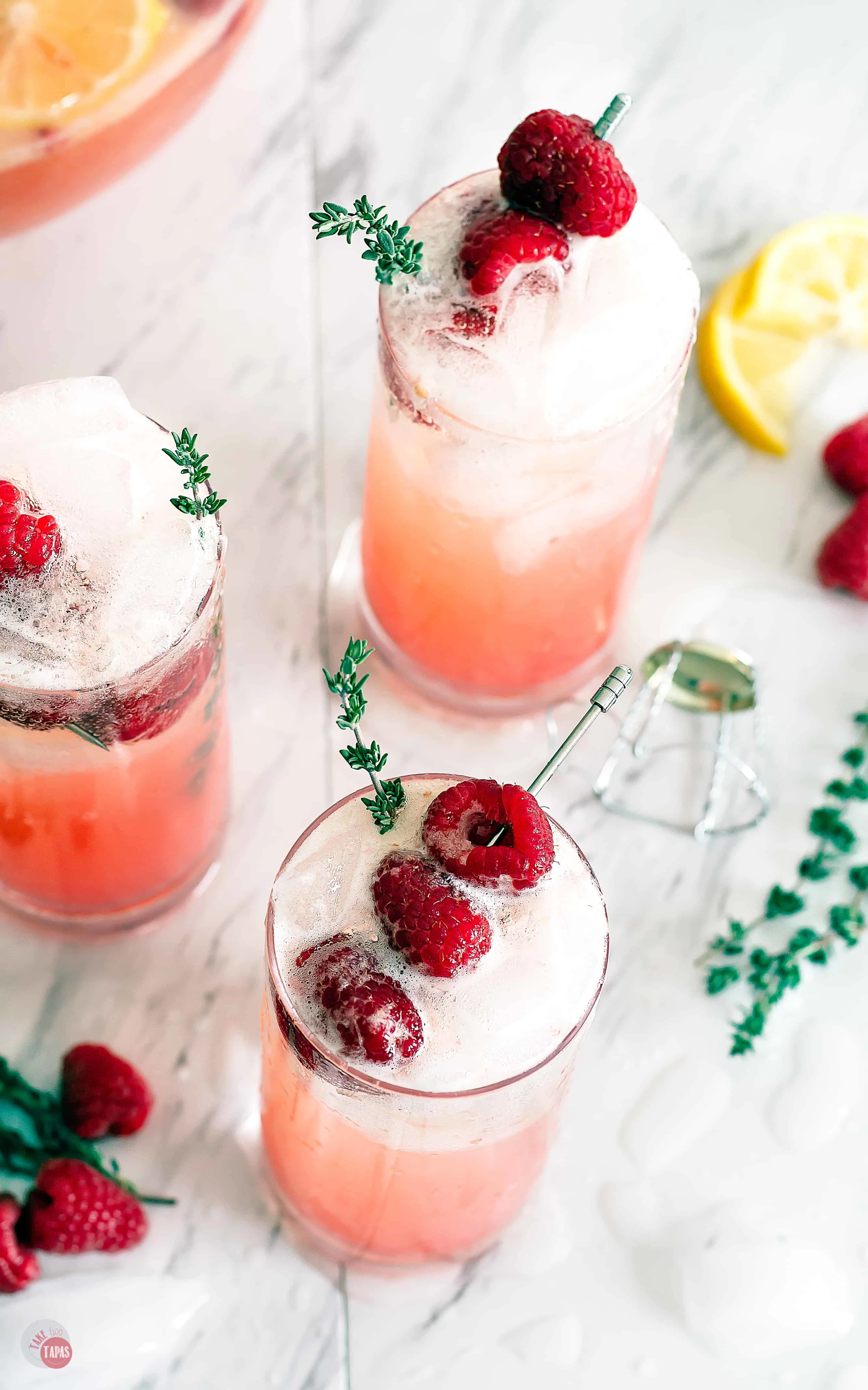 three glasses of the drink with raspberry garnish