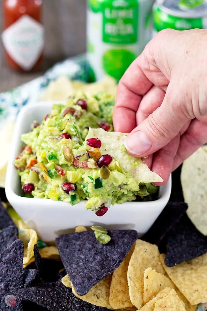 A person is dipping a chip in to the guacamole