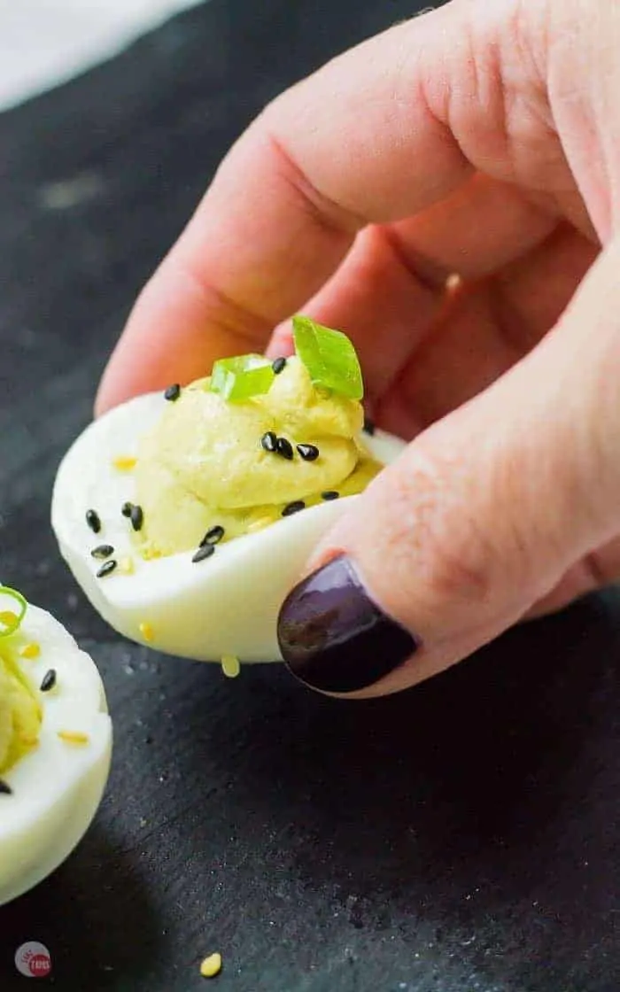 hand holding ginger wasabi deviled egg