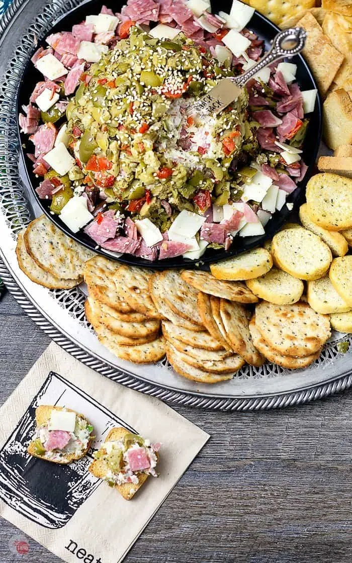 Serve this hearty Muffuletta CheeseBall with mini toasts, crackers, and crostini! #Muffuletta #CheeseBall #partyfood #MardiGras