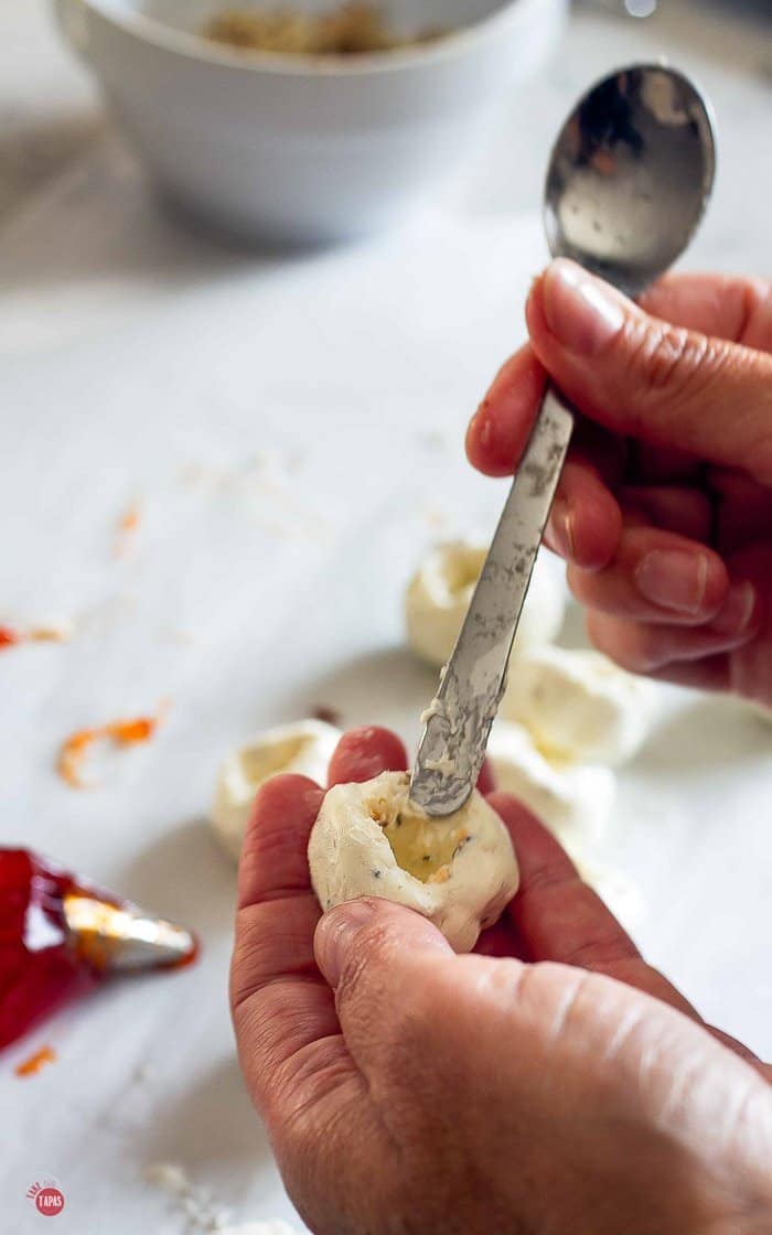 use a spoon to make a hole in the cheese ball for the pepper jelly bombs