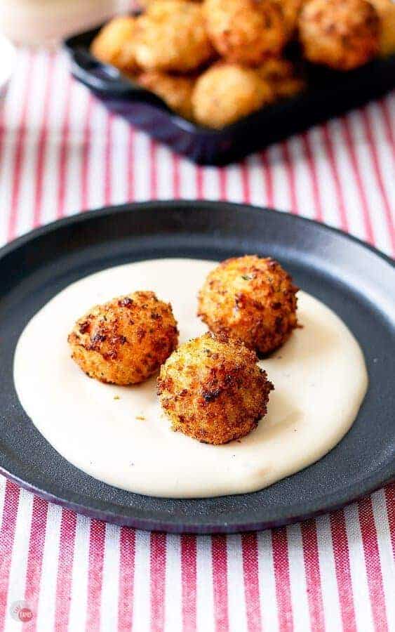 3 Arancini on top cheesy alfredo sauce