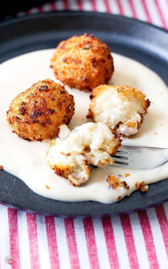 arancini on a plate with alfredo sauce