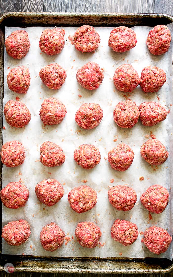 picture of portioned meatball mixture on a sheet pan