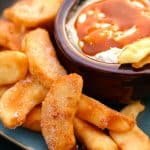 Apple fries with a caramel dip on a blue plate