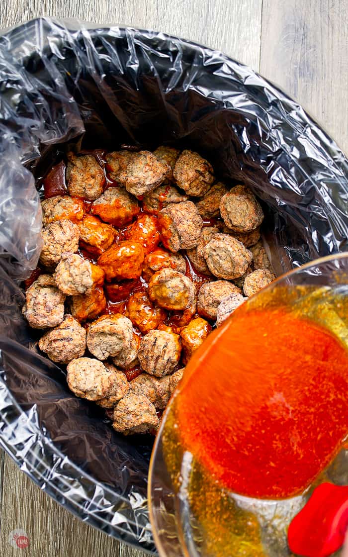 sauce pouring over meatballs in crock pot