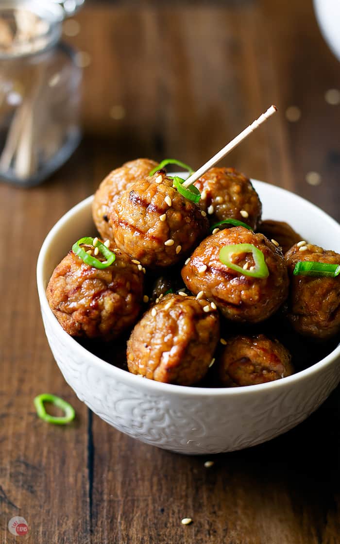 small white bowl with meatballs and sesame seeds