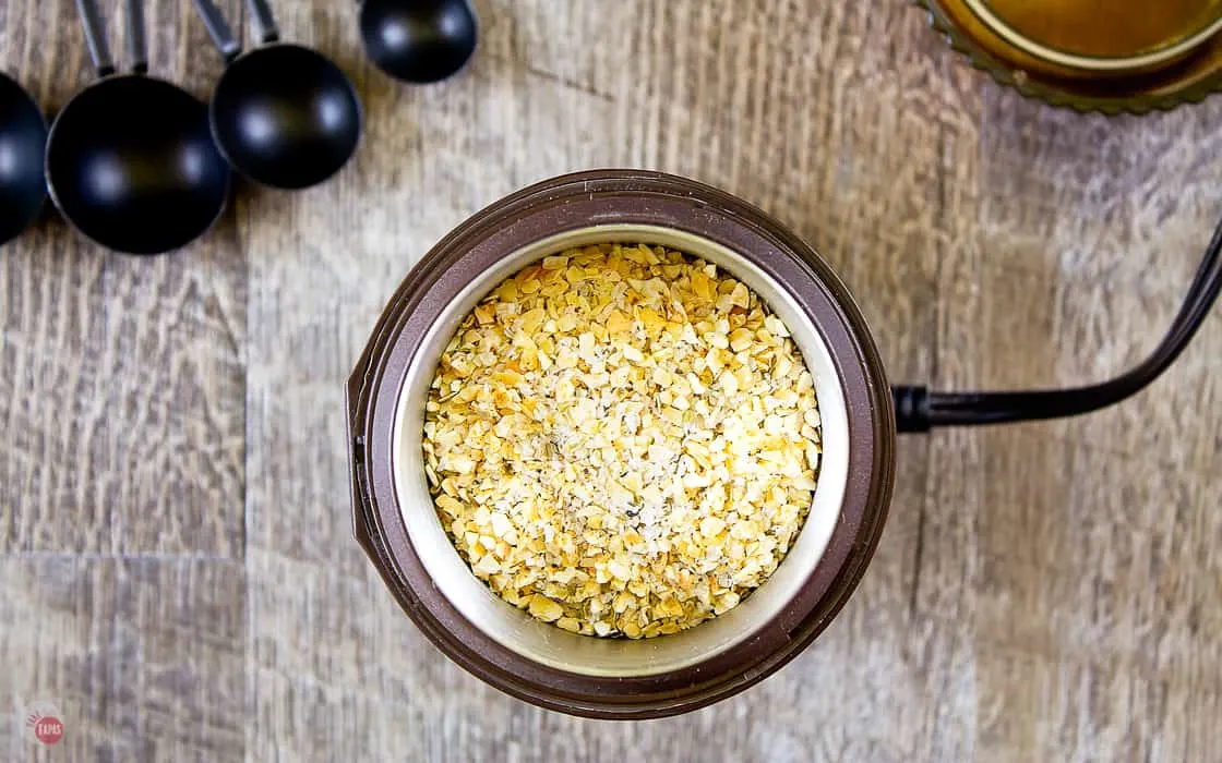 adobo seasoning in a jar with a wooden spoon