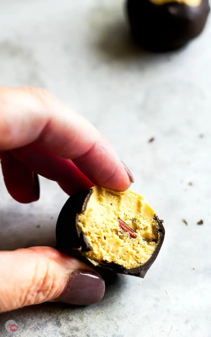 hand holding a buckeye with a bite taken out of it