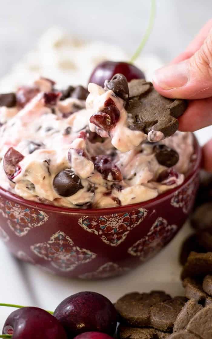 chocolate animal cracker scooping out cherry chocolate dip