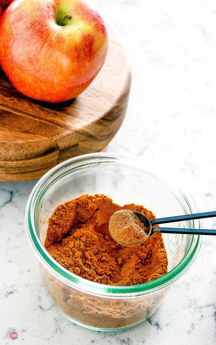 pie spice being spooned out of a jar