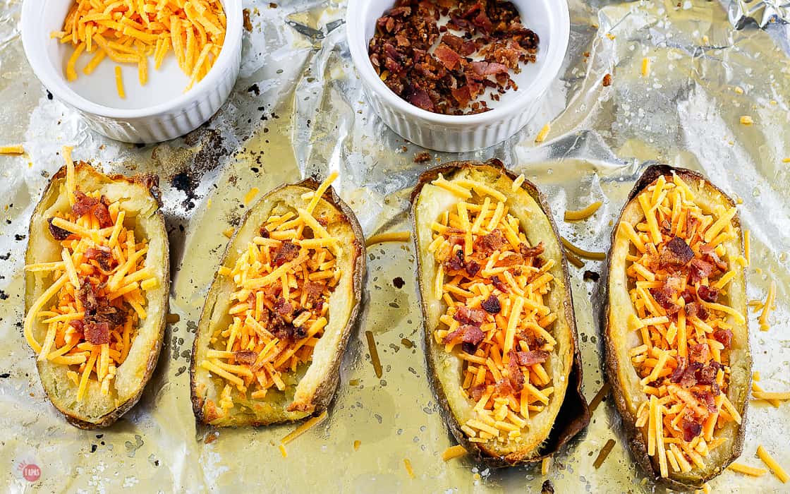 uncooked potato halves with cheese and bacon